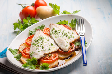 fish with potatoes and tomatoes, selective focus
