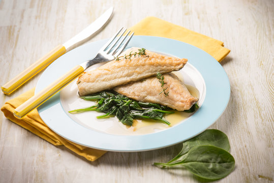 fish fillet with fresh spinach, selective focus