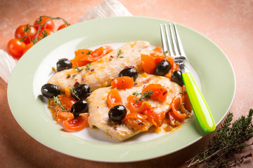 escalope with tomatoes olives and thymus, selective focus