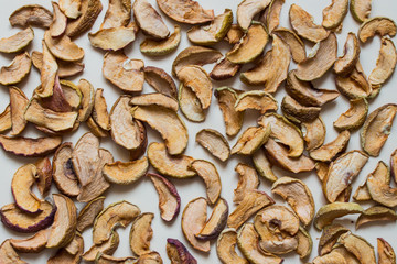 Dried organic apples on beige background. Top view.