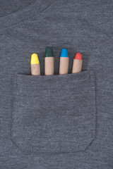 close-up view of grey male t-shirt with colorful crayons in pocket