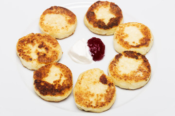 cheese pancakes on the palte with jam and sour cream. top view
