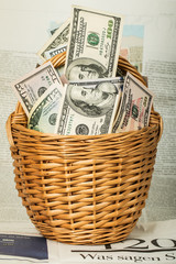 A wicker basket full of money over  table