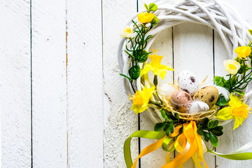 Easter background with easter eggs and spring flowers, wreath on door