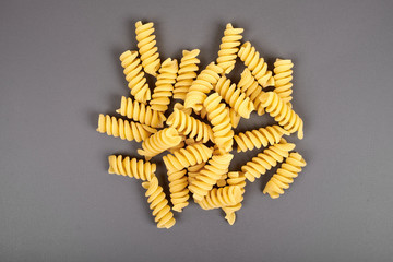 uncooked fusilli pasta noodles isolated on grey background