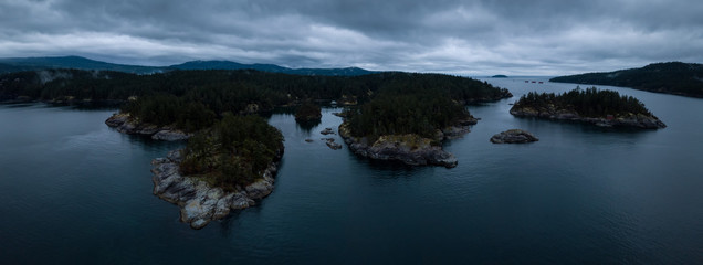 Aerial drone panoramic landscape view of Smuggler Cove during a cloudy and rainy sunset. Taken in Sunshine Coast, British Columbia, Canada.