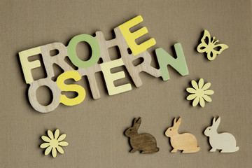 FROHE OSTERN Schrift 3 Hasen Schmetterling und Blüten in gelb auf lehmfarbenem Hintergrund aus...