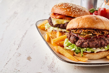 Two tasty hamburgers served with French fries
