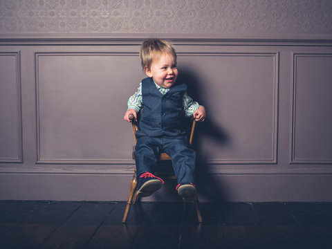 Smiling little boy sitting on a chair