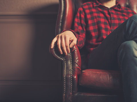 Young man sitting on a leather sofa