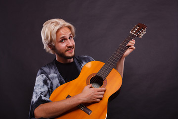 Obraz premium Blonde man playing acoustic guitar
