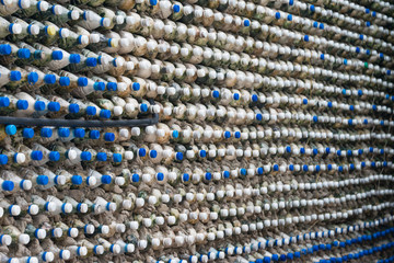 Bottle recycling: plastic bottles which have been set in concrete to form a bottle wall