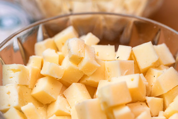 Cheese slices and pieces in a glass bowl