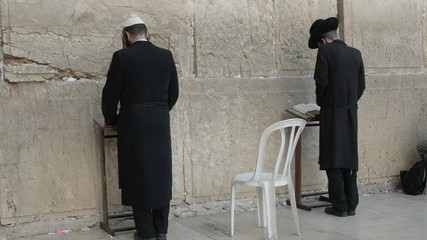 two orthodox jewish men pray at the wailing wall in jerusalem, israel