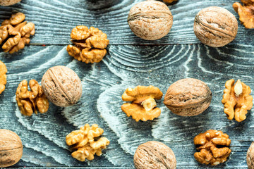 Walnuts and kernels on burlap on wooden backgound