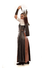 full length portrait of girl wearing brown  fantasy costume, holding a bow and arrow. standing pose...