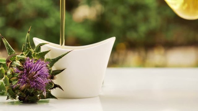 Pouring milk thistle oil