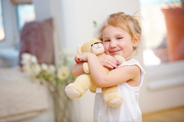 Glückliches Mädchen umarmt Teddybär
