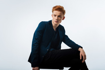 Train of thoughts. Good-looking stern dark-eyed red-haired young man wearing a black jacket and...