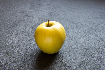 Ripe juicy apple on a dark concrete background.