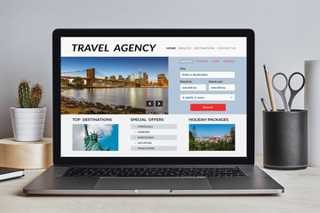 Travel agency concept on laptop screen on modern desk. All screen content is designed by me. Front view