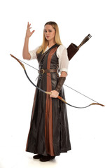 full length portrait of girl wearing brown  fantasy costume, holding a bow and arrow. standing pose...