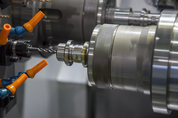 The  CNC lathe tapping the steel rod .The  modern machining process.