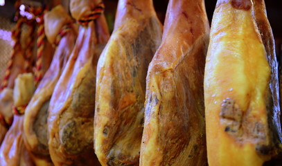 Spanischer Serrano-Schinken hängend in einer Reihe von Schinkenkeulen