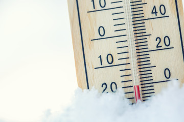 Thermometer on snow shows low temperatures under zero. Low temperatures in degrees Celsius and fahrenheit. Cold winter weather twenty under zero