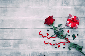 Valentine background with red rose flower and small present box on rustic wood. Happy lovers day gift mockup, copy space