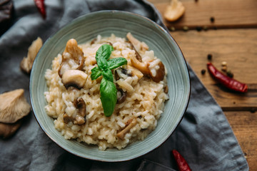 Risotto with mushrooms on an old wooden background. Rustic style.