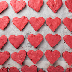 Obraz na płótnie Canvas Red velvet heart cookies on baker paper. Baking tray with sweet biscuit cakes. Valentine days food