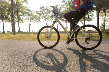 woman cyclist riding bike in a tropical park