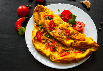 omelette in a plate on dark wooden background