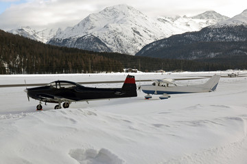 Private planes, propellers and jets in the snow covered landscape of the alps Switzerland in ST Moritz