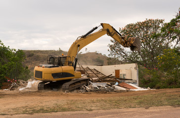 Bulldozer demolishing house