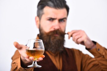 Waiter curling mustache holds whiskey or scotch. Beverage concept.