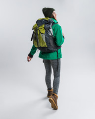 happy traveler in warm clothing with backpack, isolated on grey