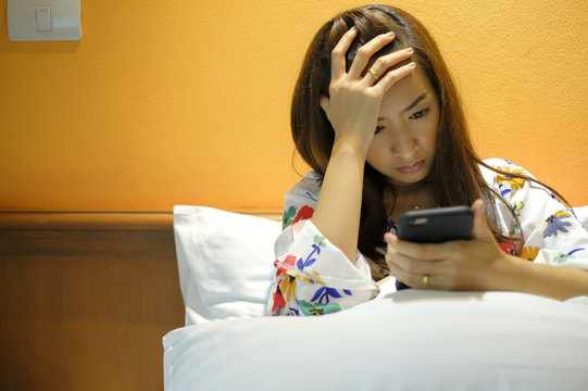 beautiful girl sad and serious after read bad news on mobile phone in bedroom