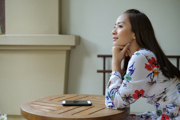 Asian girl sit relax on chair wood after use mobile phone