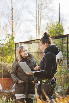 Two women with laptop outside
