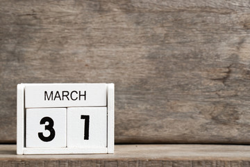 White block calendar present date 31 and month March on wood background