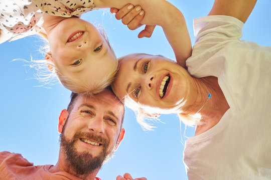 Portrait of happy family huddling under blue sky