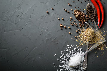  pepper black peas and salt and green dried grass seasoning in metal antique spoons and hot chili...