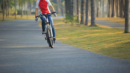 woman cyclist riding bike in tropical park