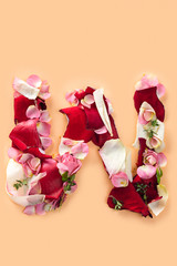 Letter W made from red roses and petals isolated on a white background