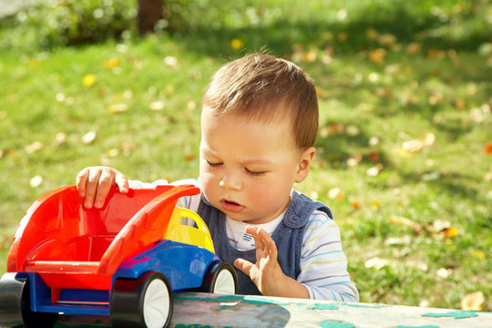 Little Boy Playing With A Toy Truck