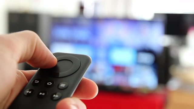 Watching Smart TV And Using Modern Black Remote Controller, Blurred TV
