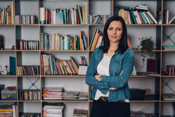 Woman posing in front of the bookshelves at home