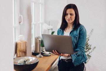 Woman using a handheld laptop at home